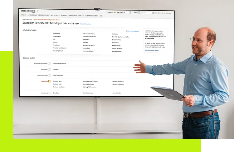 Online Verkaufsplattformen - Softwareentwickler hält ein Tablet und präsentiert auf einem großen Bildschirm Produktlisting und Kategoriestruktur für erfolgreiche Verkäufe auf Online-Verkaufsplattformen